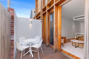 Un balcón con una mesa y sillas en una pared de ladrillo. en Stylish 2-bed Victorian Terrace in Carlton, en Melbourne