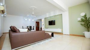 un soggiorno con un divano marrone e una TV di Tima Residence a Dar es Salaam