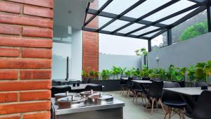 a restaurant with tables and chairs and a brick wall at The Lovedale Kodaikanal Stay & Hotel in Kodaikānāl