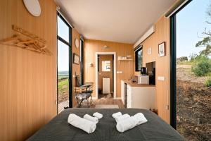 una camera da letto con un letto con asciugamani bianchi sopra di Mountain Views X by Tiny Away a Yarragon