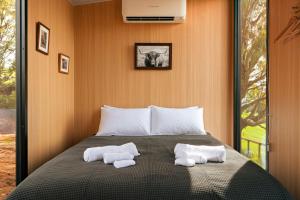 una camera da letto con un letto con due asciugamani sopra di Mountain Views X by Tiny Away a Yarragon