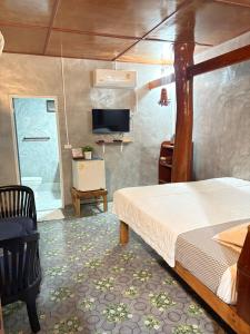 a bedroom with a bed and a television in a room at ลีลา รีสอร์ท Leela Resort in Ban Tha Phae