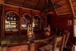 eine Bar mit einem Tisch und einigen Weingläsern in der Unterkunft Lion Tree Top Lodge in Guernsey Nature Reserve + 23 Fotos