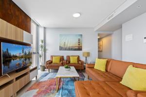 Central 2-Bed with Parking & Stunning Views في سيدني: غرفة معيشة مع أريكة وتلفزيون