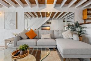 un salon avec un canapé et une table en verre dans l'établissement Chic 2-Bed Cabin-Style Home by Mooloolaba Beach, à Mooloolaba