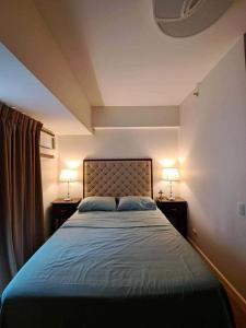 a bedroom with a bed with two lamps on tables at Ayah Avida Tower Urban escape in Cebu City