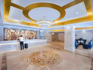 a man taking a picture of a lobby with a chandelier at Vienna Hotel Shanghai Songjiang Xiaokunshan in Chengxi