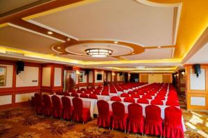 a large room with red chairs and a large room with at Vienna Hotel Hebei Tangshan Nanhu Park in Tangshan