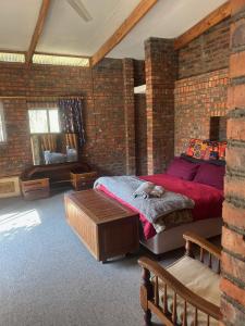 a brick walled bedroom with a bed with a cat on it at Biba's Rooms in Smithfield