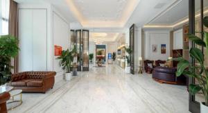 a large lobby with couches and chairs and plants at Vienna Hotel Shaanxi Xiianyang Yangling South Station in Yang-ling-chen