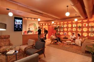 um grupo de pessoas sentadas numa sala de espera em Coeo Hernan Ruiz Rooftop Pool Hostel em Málaga