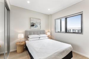 une chambre blanche avec un lit et une fenêtre dans l'établissement First Floor 3-Bed Stunning Unit by The Ocean, à Kiama 6 autres photos