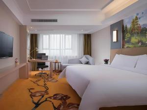 a hotel room with a large bed and a desk at Vienna Hotel Xuzhou Junsheng Plaza Benteng Avenue Metro Station in Xuzhou +216 photos