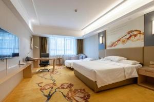 a hotel room with two beds and a television at Vienna Hotel Xuzhou Junsheng Plaza Benteng Avenue Metro Station in Xuzhou