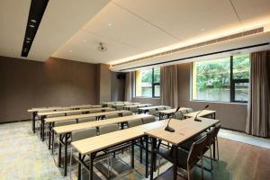 ein Klassenzimmer mit Tischen und Stühlen in einem Raum in der Unterkunft Echarm Hotel Chengdu Happy Valley Southwest Jiaotong University in Chengdu
