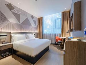 a hotel room with a bed and a desk at Borrman Hotel Wuzhou College Fumin Road in Wuzhou +156 photos