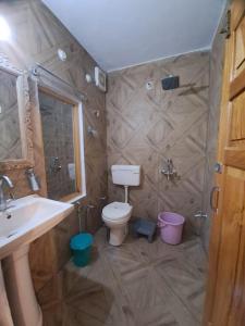 une salle de bain avec toilettes, lavabo et douche dans l'établissement Gopi Homestay & Restaurant - Jim Corbett, à Tota Ām