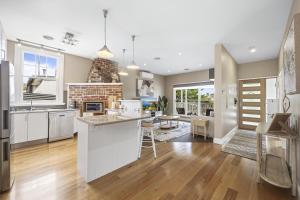 a kitchen with white cabinets and a fireplace at Lovely 3-Bed with Alfresco Dining in Prime Suburb in Ballarat
