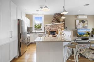 a kitchen with white cabinets and a brick wall at Lovely 3-Bed with Alfresco Dining in Prime Suburb in Ballarat +9 photos