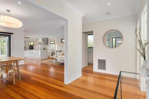 comedor y sala de estar con mesa y espejo en Luxurious 3-Bed Home with Outdoor Spa by Beach, en Tootgarook