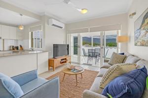 a living room with a couch and a table at Trinity Beach Retreat with Pool and Scenic Views in Trinity Beach