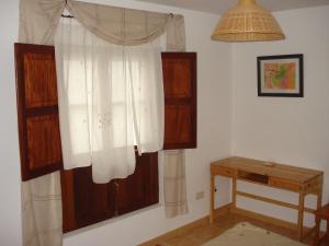 a room with a window with white curtains and a table at Casa Nueva Carmen in Pendueles