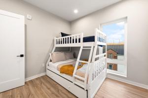 a white bedroom with a bunk bed and a window at Union Market Lux 2BD Condo in Washington, D.C. +12 photos