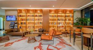 a lobby with couches and tables and a wall with shelves at Echarm Plus Hotel Nanning Convention and Exhibition Center Medical University in Nanning
