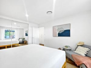 - une chambre blanche avec un lit et un canapé dans l'établissement Spacious 2-Bed Townhouse with BBQ by the Beach, à Surf Beach 11 autres photos