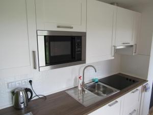 una cucina con lavandino e forno a microonde di Apartmán Stožec Ema a Stožec