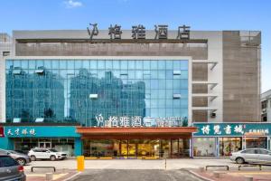 a large glass building with chinese writing on it at GYA Hotel Heze Zhonghua Road Jiahe Plaza in Heze
