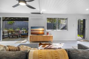 un salon avec un canapé et une télévision à écran plat dans l'établissement Trendy 2-Bed Home with Outdoor Entertainment, à Yaroomba