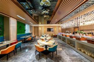 un restaurant avec des tables et des chaises dans une salle dans l'établissement Borrman Hotel Zhongshan Lihe Plaza, à Zhongshan