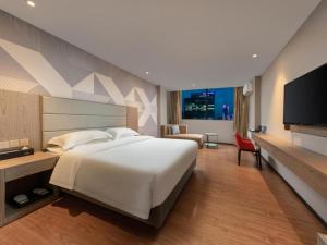 une chambre avec un grand lit et une télévision à écran plat dans l'établissement Borrman Hotel Zhongshan Lihe Plaza, à Zhongshan 263 autres photos
