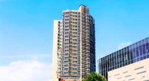 un grand bâtiment au milieu de deux bâtiments dans l'établissement Echarm Hotel Wuhan Gaotie Jianshe 2nd Road Metro Exit, à Wuhan