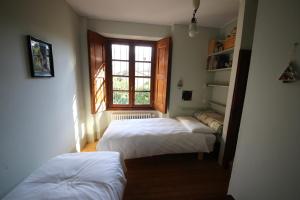 two beds in a small room with a window at Palazzo Guicciardi in San Bernardo