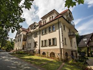 un gran edificio blanco al lado de una calle en TatryTOP Radowid basen sauna, en Zakopane