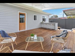 een terras met stoelen en een tafel bij Elegant Beachside Retreat with Luxurious Amenities in Tomakin