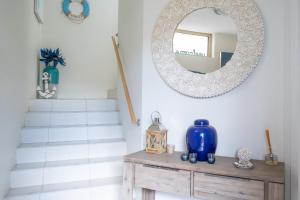 a mirror on a wall next to a wooden table and stairs at 3-Bed with Beach Views and Entertainment Area in Surf Beach