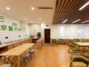 ein Büro mit Tischen und Stühlen und eine Cafeteria in der Unterkunft GreenTree Inn Express Wuxi Jiangyin Wanda Plaza Tongfu Road in Jiangyin