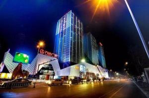 ein großes Gebäude mit blauen Lichtern auf einer Stadtstraße bei Nacht in der Unterkunft GreenTree Inn Express Wuxi Jiangyin Wanda Plaza Tongfu Road in Jiangyin