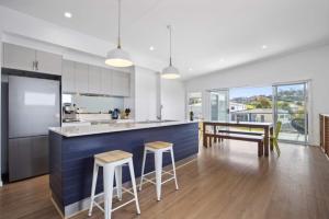 cocina con encimera azul, mesa y sillas en 3-Bed Coastal Getaway with Direct Beach Access, en Long Beach