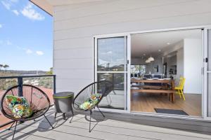 Un balcón con dos sillas y una mesa de comedor. en 3-Bed Coastal Getaway with Direct Beach Access, en Long Beach