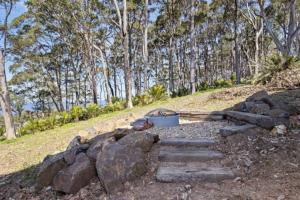 Un montón de rocas y una olla en una colina con árboles. en 3-Bed Coastal Getaway with Direct Beach Access, en Long Beach