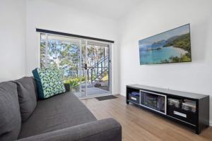 Una sala de estar con un sofá y un televisor de pantalla plana. en 3-Bed Coastal Getaway with Direct Beach Access, en Long Beach 9 fotos más