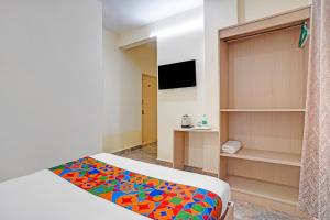 - une chambre avec un lit et une couverture colorée dans l'établissement FabHotel Platinum - Shivaji Nagar, Commercial Street, à Bangalore