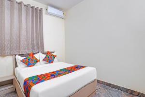 - une chambre avec un lit et des oreillers colorés dans l'établissement FabHotel Platinum - Shivaji Nagar, Commercial Street, à Bangalore
