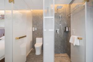 a bathroom with a toilet and a shower at Nost algia S Hotel Shanghai Fudan University 时光漫步S酒店上海复旦大学五角场地铁站店 Free fresh ground coffee,Free laundry service in Shanghai