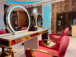 Un vestidor con sillas rojas y un espejo. en Glory Regency Hotel, en Yuba