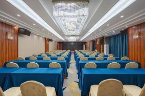 ein Konferenzraum mit blauen Tischen und Stühlen in der Unterkunft Vienna Hotel Guangdong Zhuhai Mingzhu Station Guozheng in Zhuhai + 173 Fotos